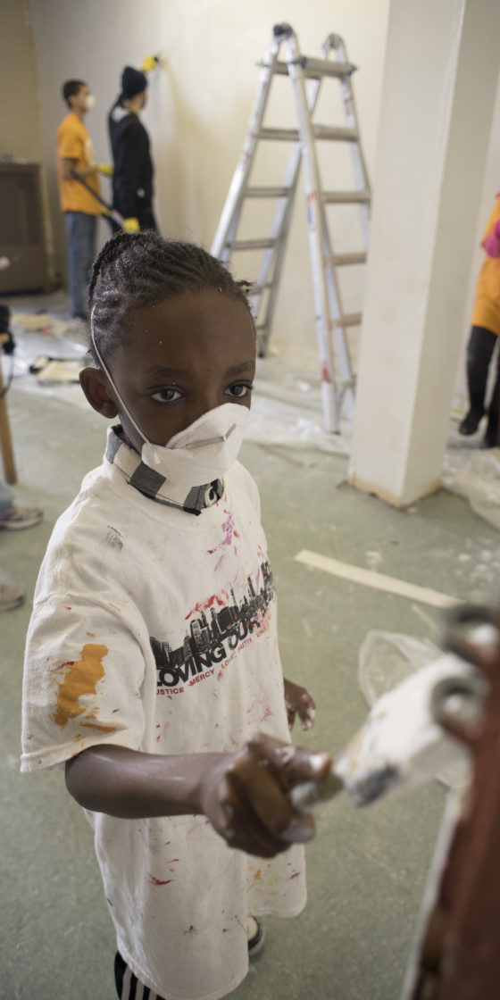 kid volunteering to paint wall