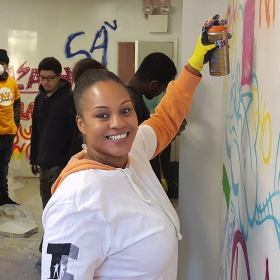 woman smiling while spray painting