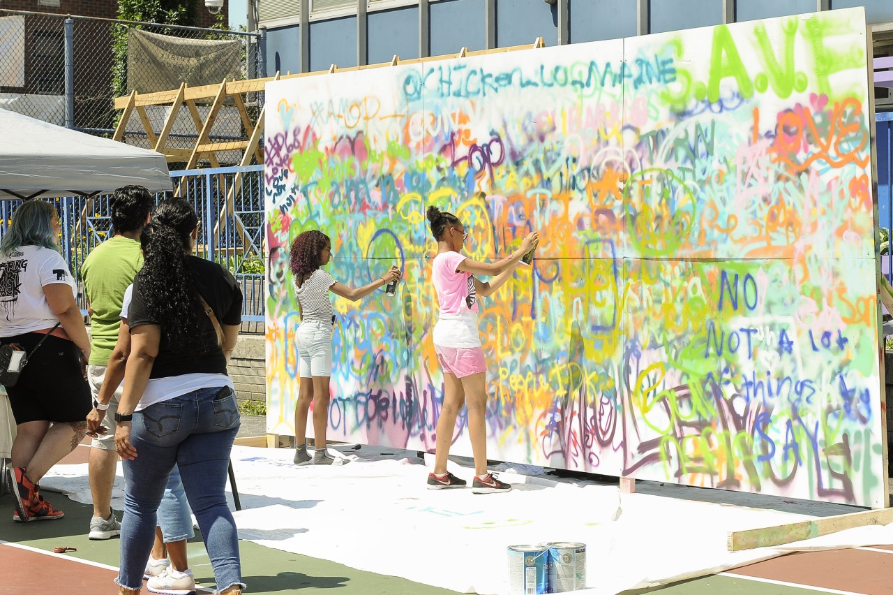 kids spray painting wall